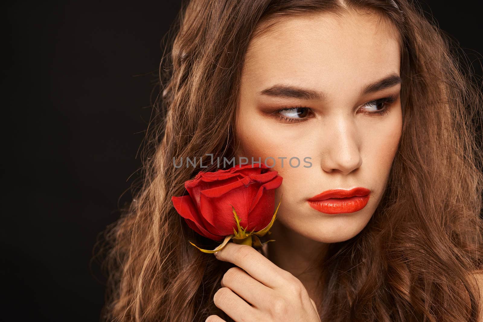 woman with a red rose on a dark background long hair makeup red lips by SHOTPRIME