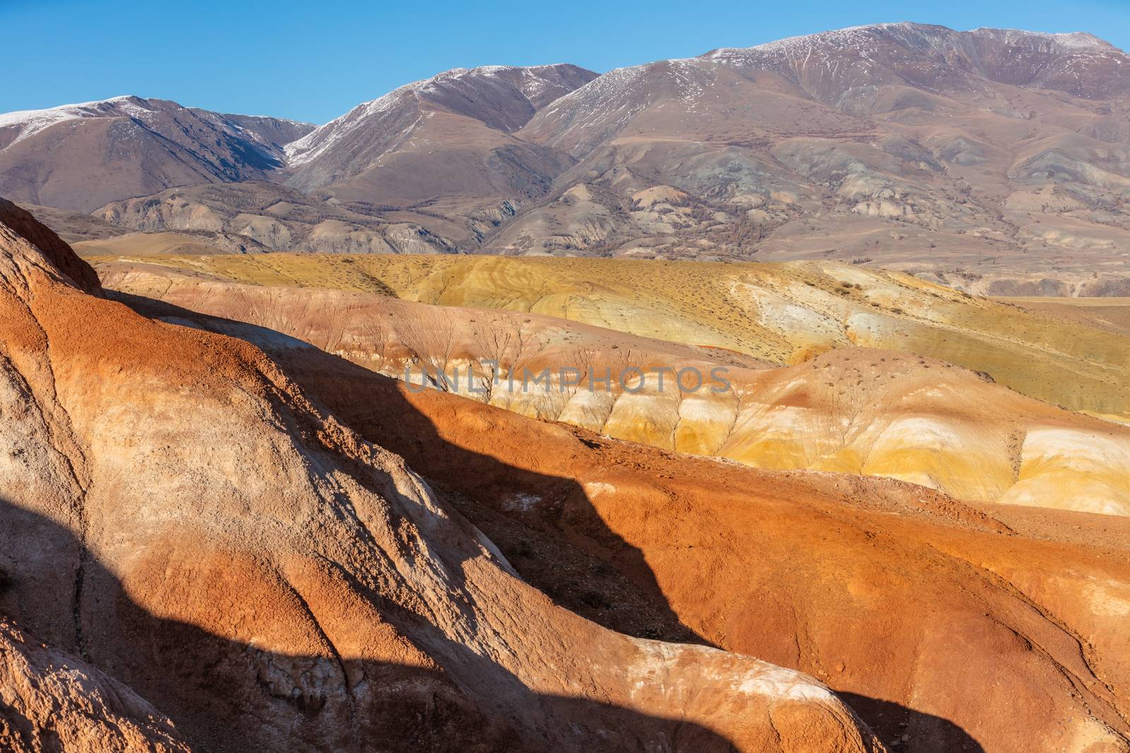 High angle shot of massive red mountains in Kyzyl-Chin valley, also called Mars valley. Blue sky as a background. Altai, Siberia, Russia.