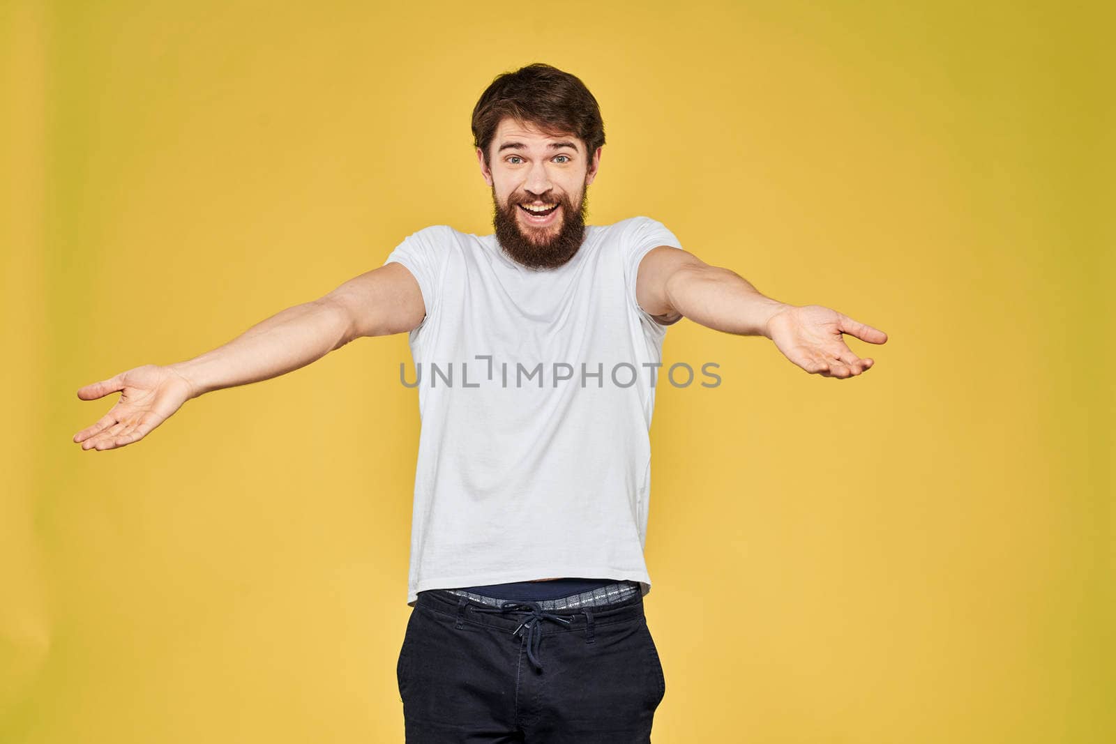 Man gesturing with hands emotions lifestyle white t-shirt yellow isolated background by SHOTPRIME