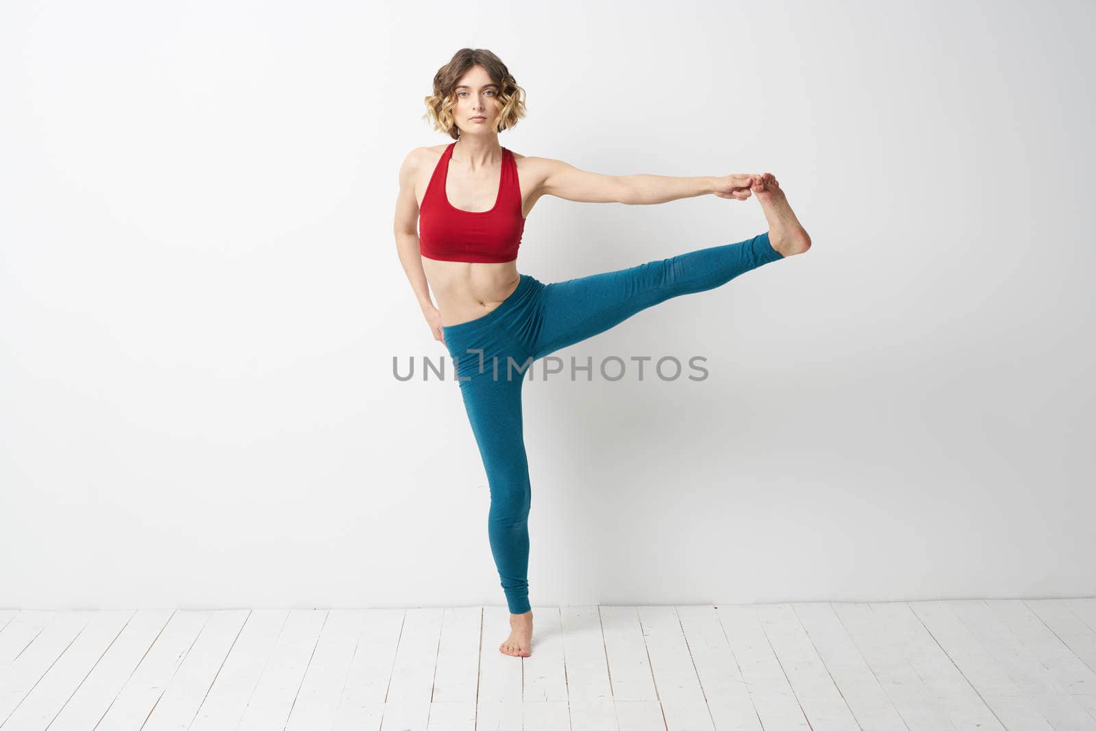 A woman in full growth In a bright room yoga meditation is engaged in sports. High quality photo