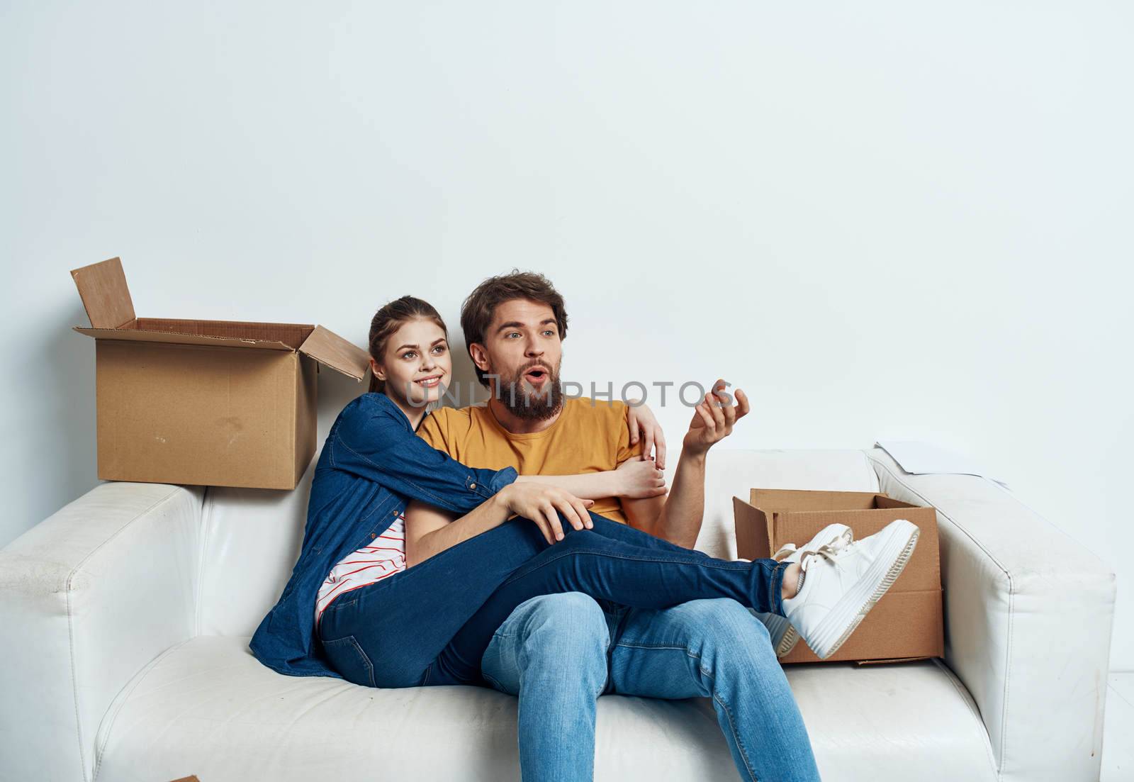 Young couple boxes with things on moving room interior. High quality photo