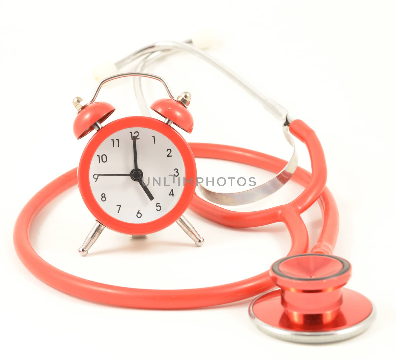 A concept focusing on time and medical issues with a stethoscope and red alarm clock.