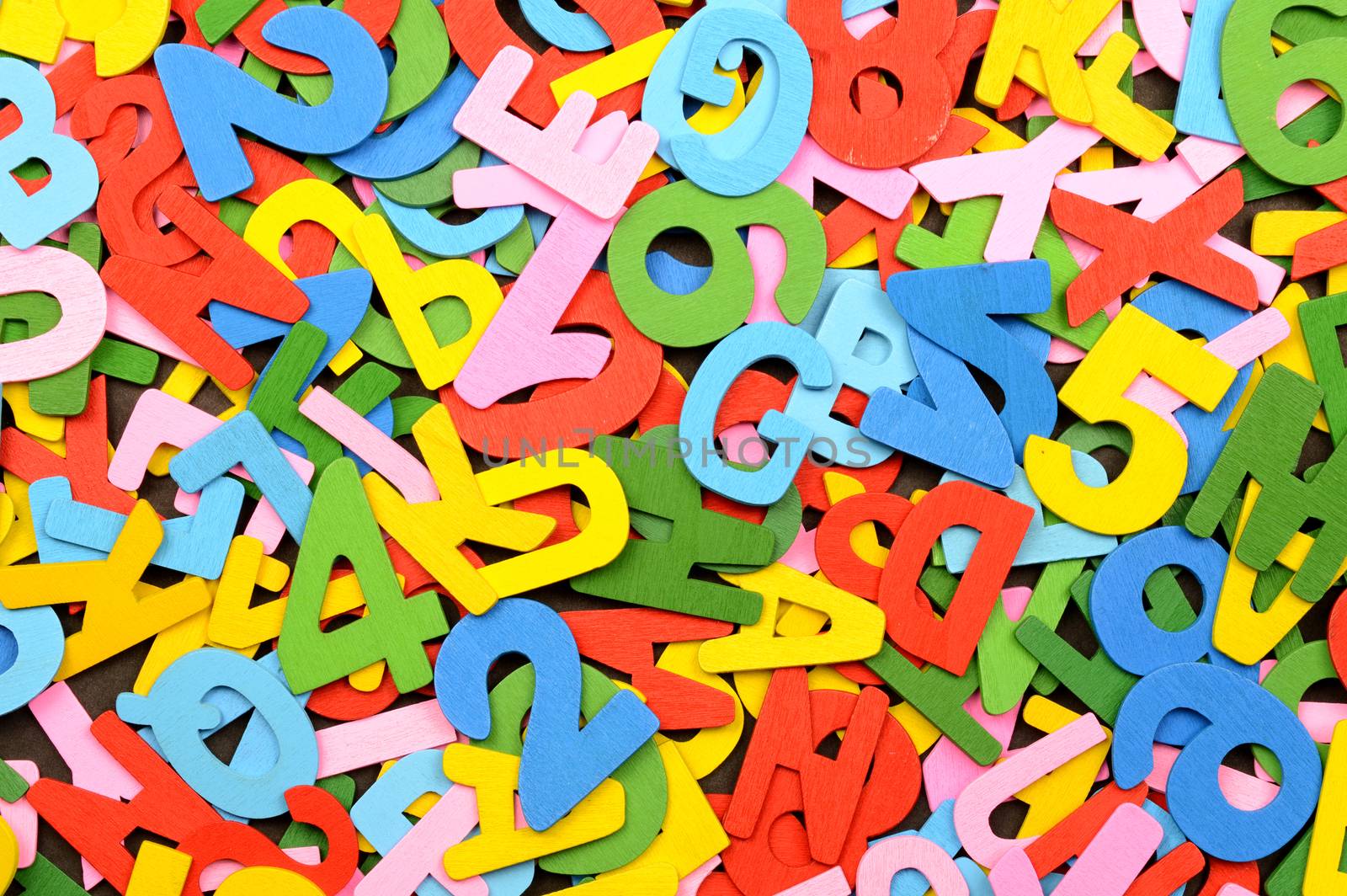 A full frame closeup shot of various english alphabet cutouts from wood and painted in multicolours.