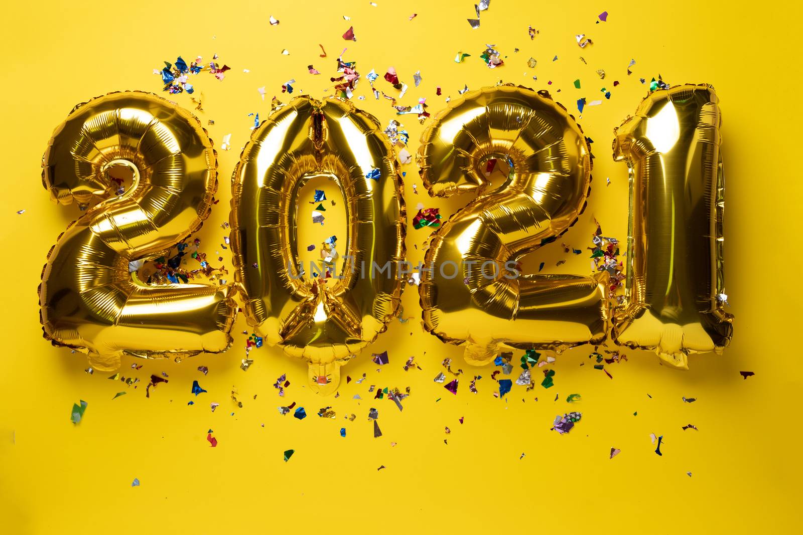 2021 numbers for new year from golden foil balloon and confetti stock photo