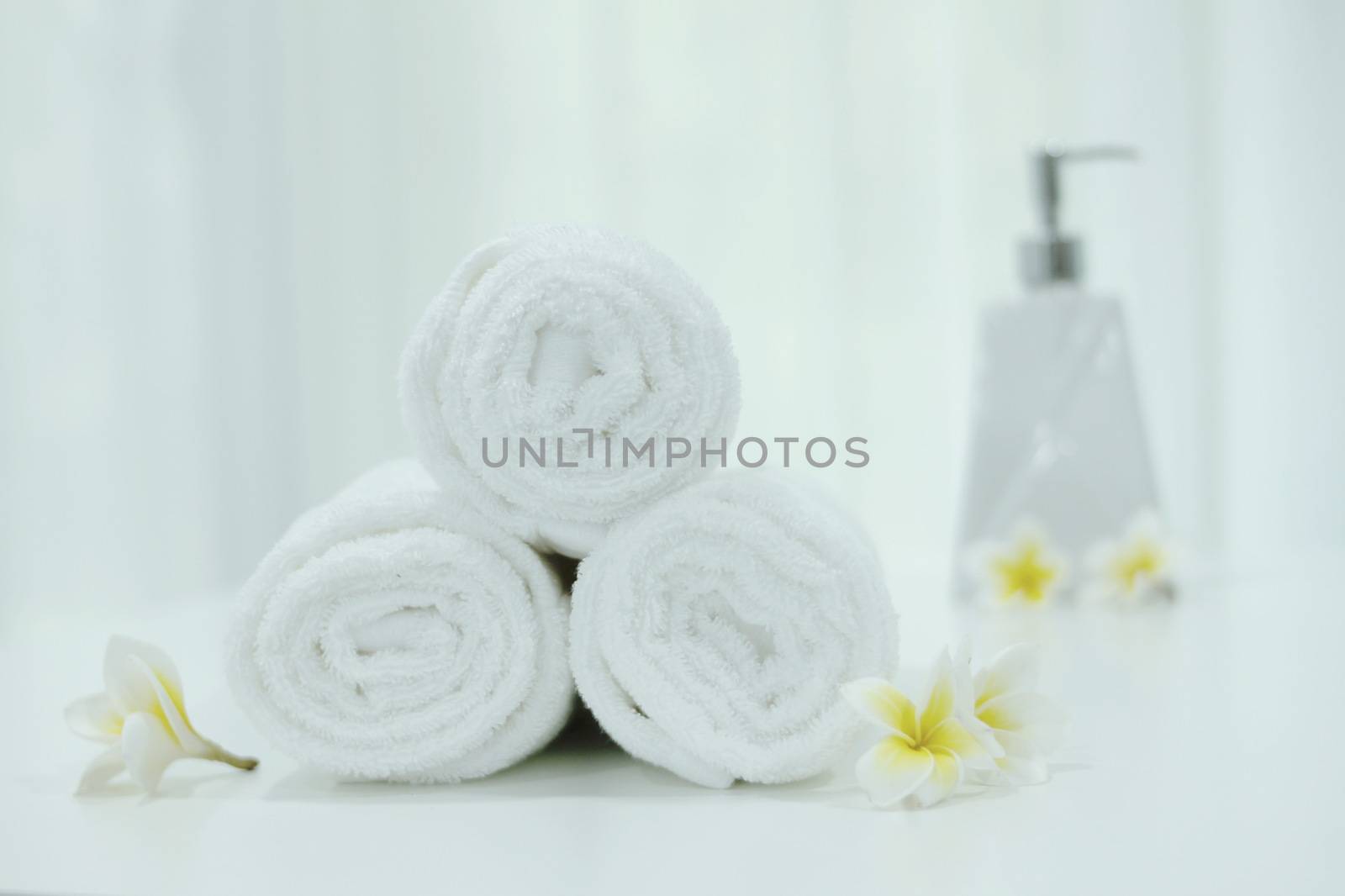 Roll up white towels in the basket on the table. by BirdKS