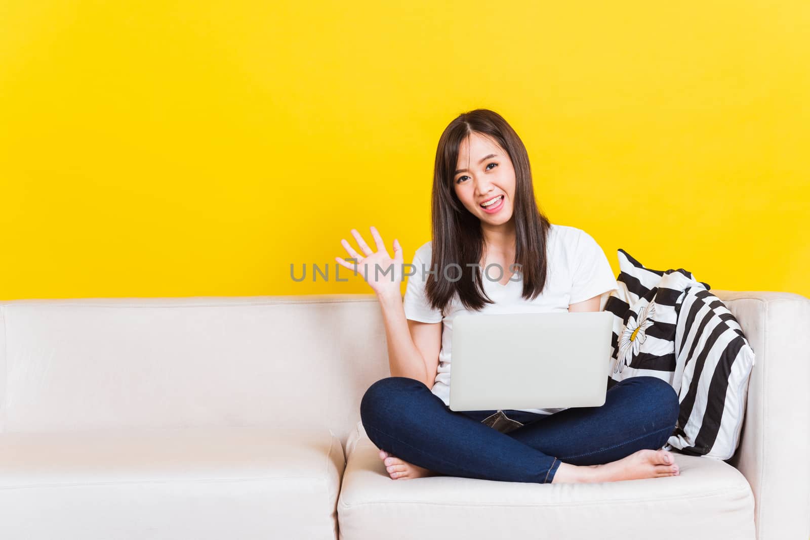 Young woman work from home she sitting on sofa using laptop comp by Sorapop