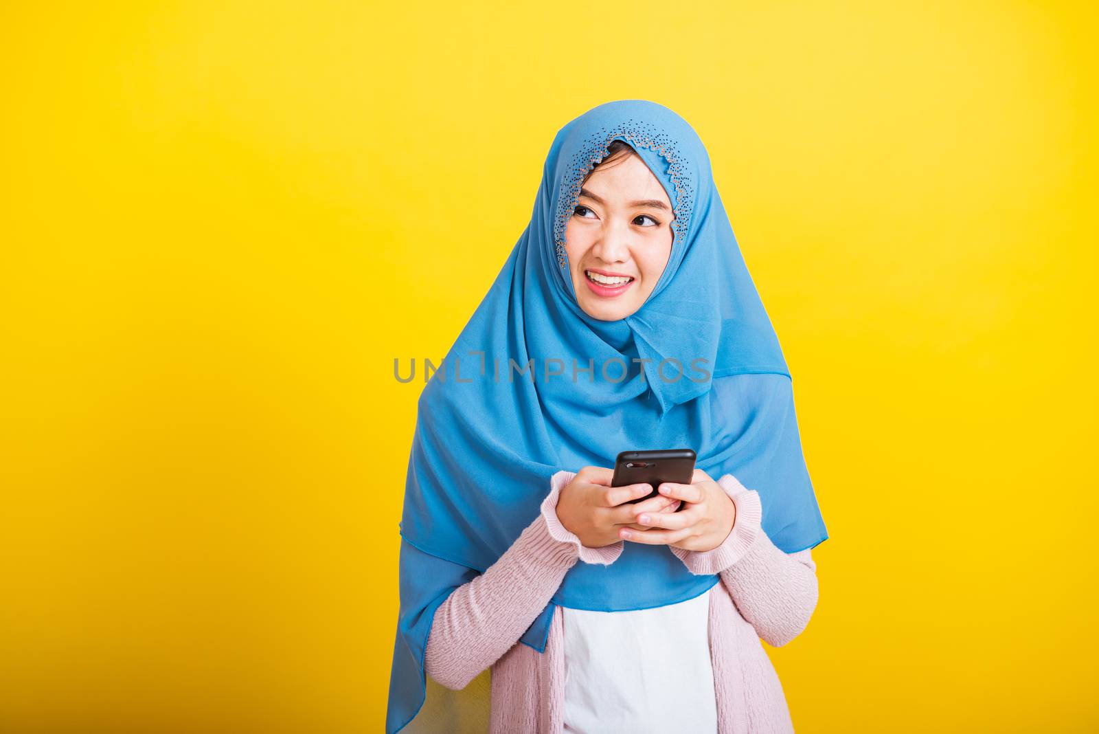 Asian Muslim Arab woman Islam wear hijab smile she using hold mo by Sorapop