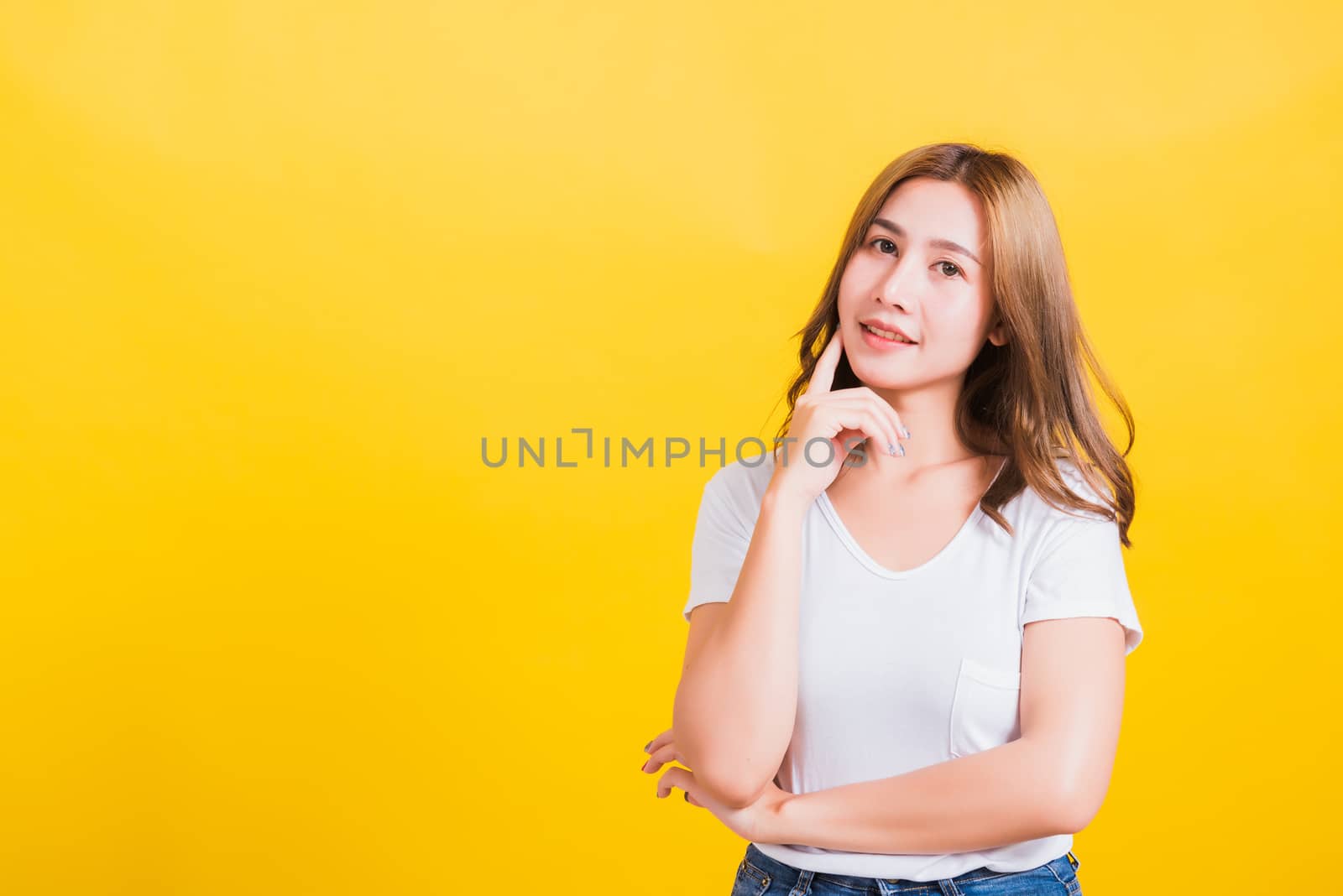 woman smile wear white t-shirt standing relaxed thinking about s by Sorapop