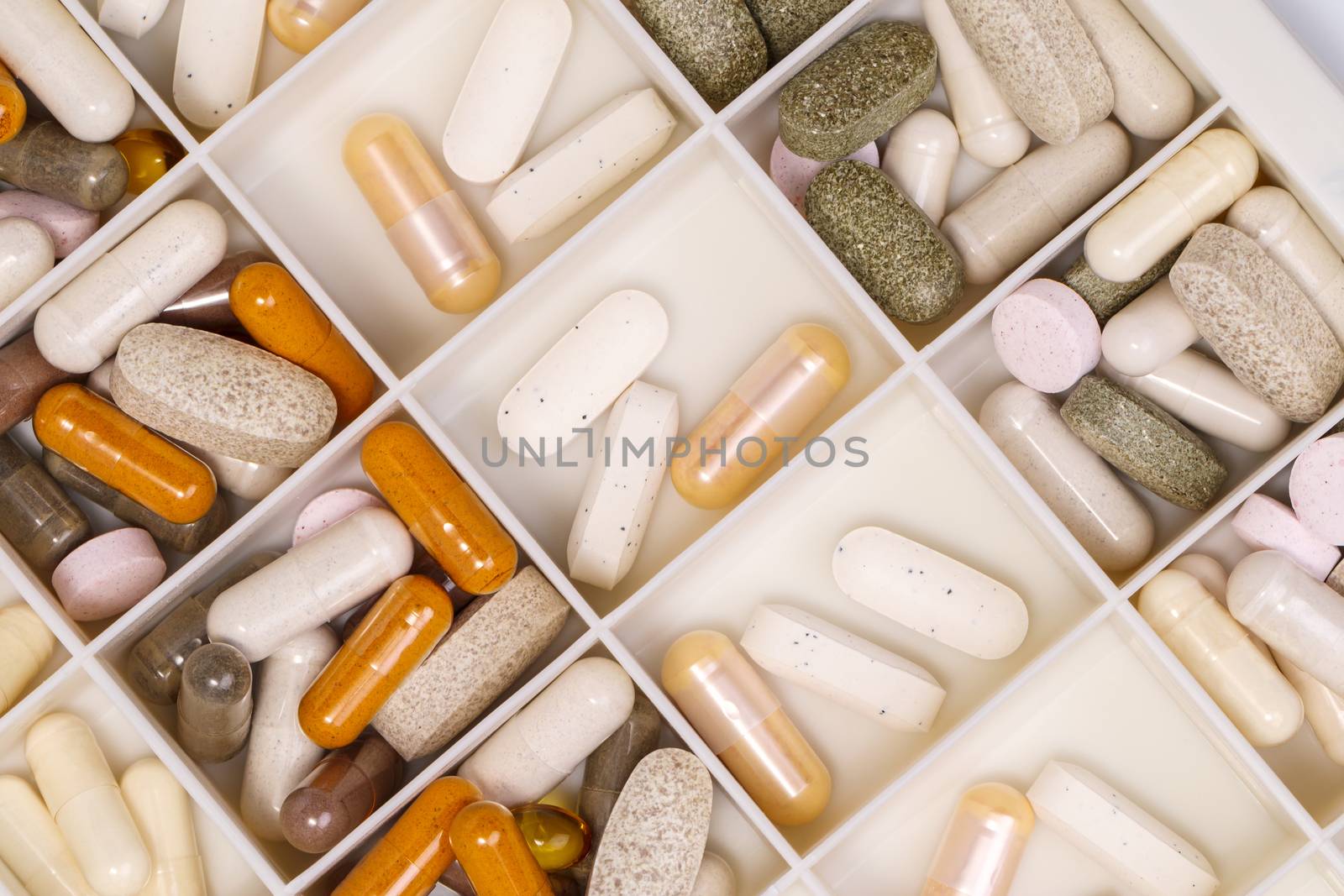 plastic medicine organizer with pills and capsules, medicines for health, pharmaceutical health care and sciences concept, shallow depth of field