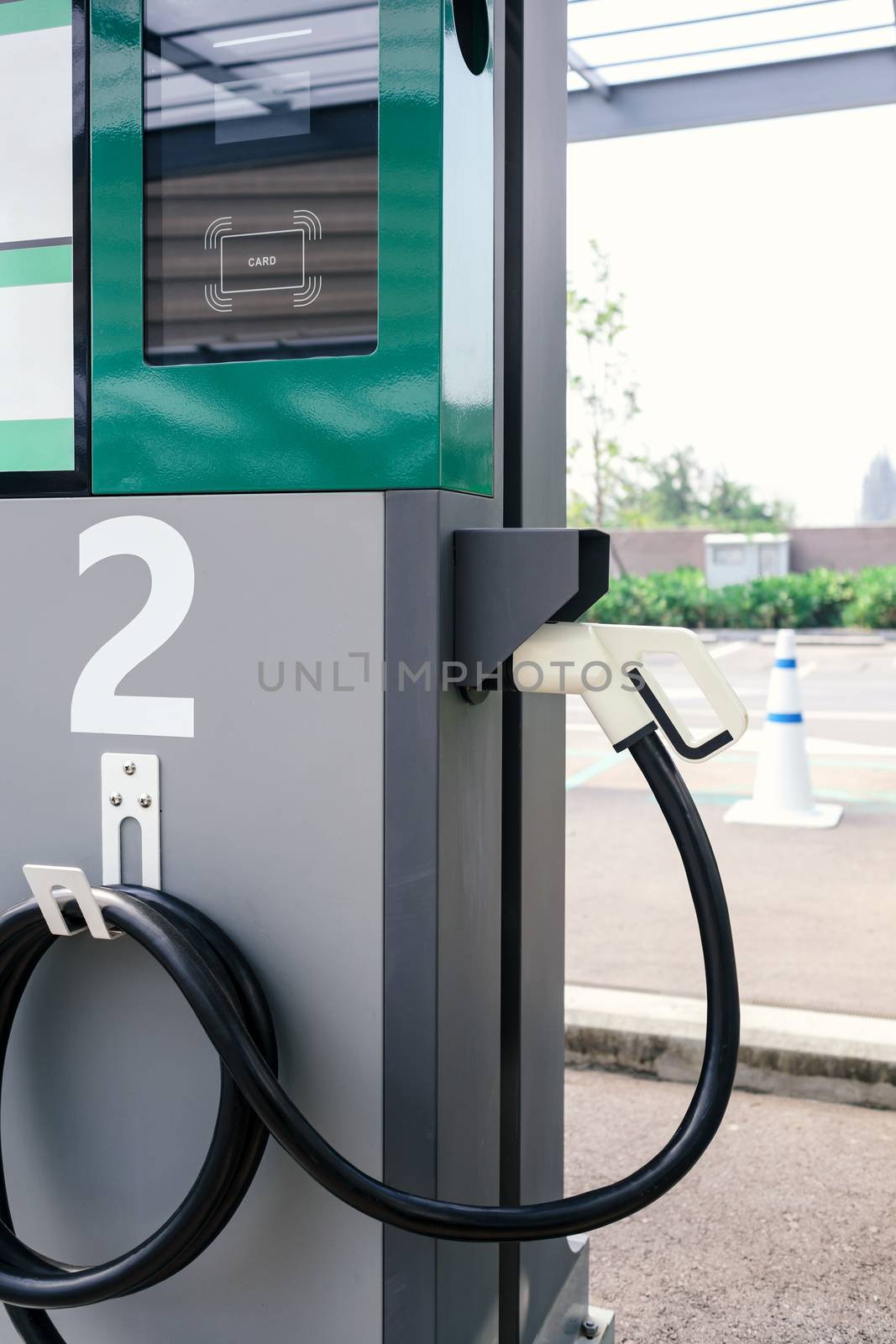 power supply connecter to plug-in electric vehicle or electric car at charging station in car park area of shopping plaza. charging technology for future automotive and city life.