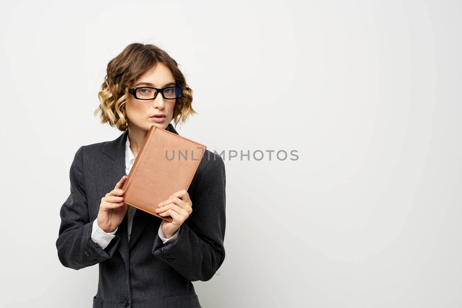 Business woman with notepad and glasses work light background cropped view of suit model. High quality photo