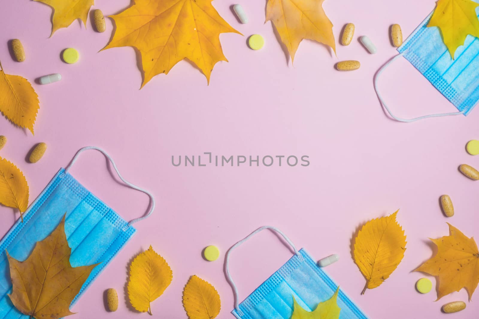 Autumn fallen leaves and medical masks and medicines on black background.