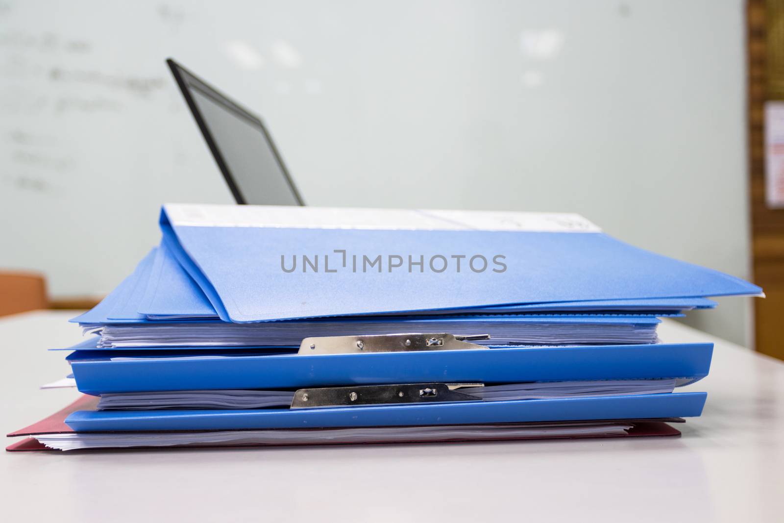 Blue Document folder on table at office with laptop background