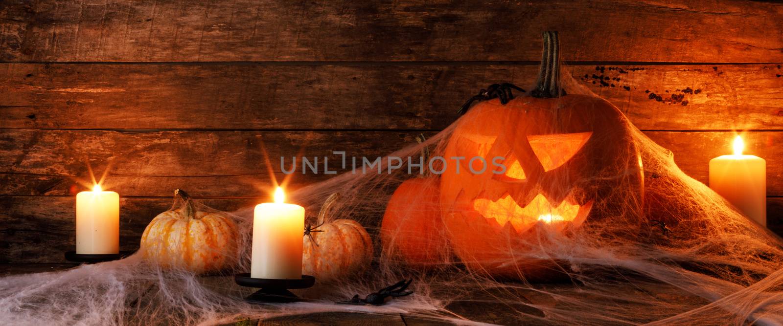 Jack O Lantern Halloween pumpkins, spiders on web and burning candles