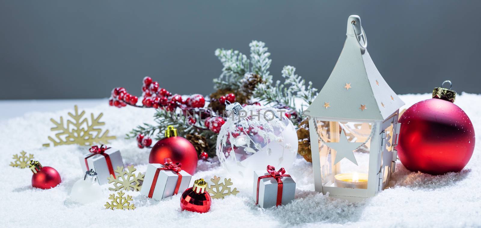 Christmas holidays card with gifts , balls , and white glowing lantern in snow
