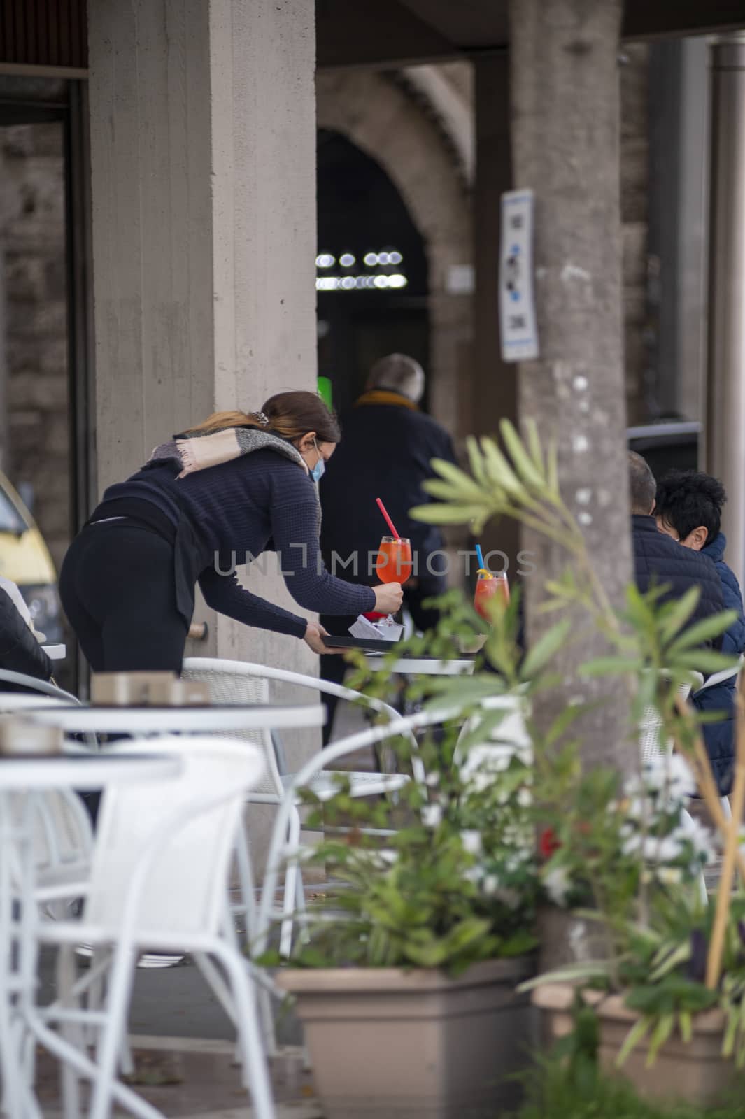 terni,italy october 27 2020:bartender bringing aperitif to the table