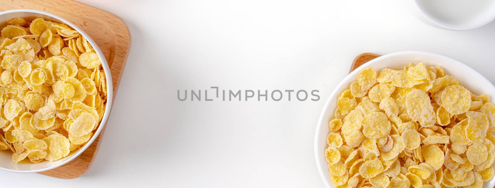 Top view of corn flakes bowl sweeties with milk and orange on white background, flat lay overhead layout, fresh and healthy breakfast design concept.