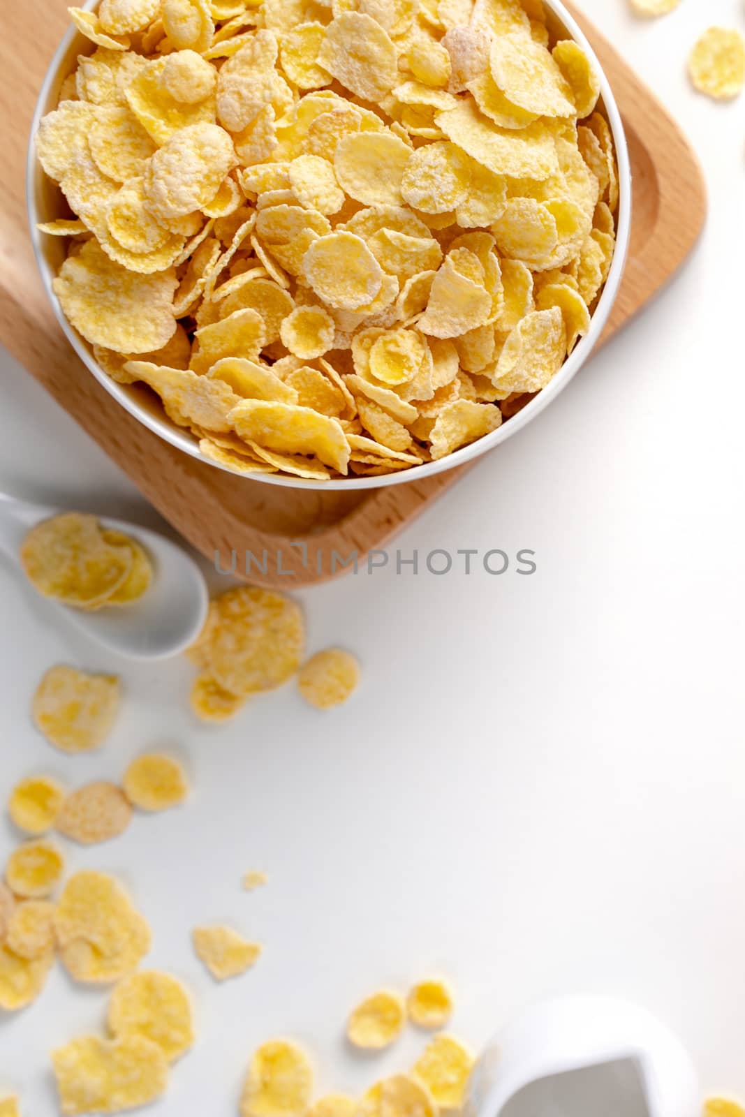 Top view of corn flakes bowl sweeties with milk and orange on white background, flat lay overhead layout, fresh and healthy breakfast design concept.