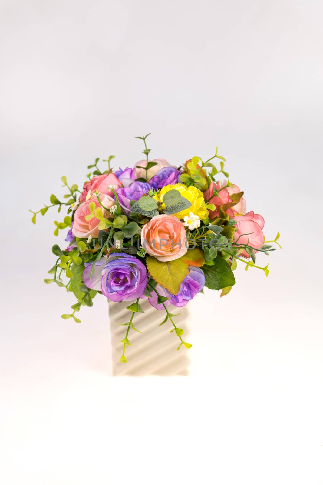 Vase plastic flowers in the room isolated on white background.