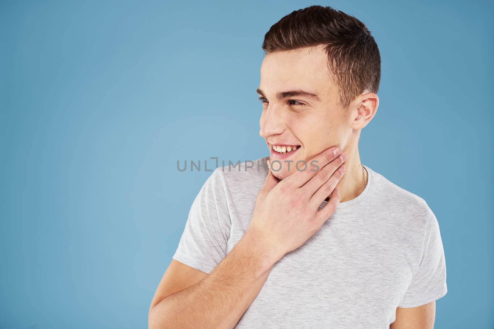 Emotional man in white t-shirt cropped view on blue background lifestyle by SHOTPRIME