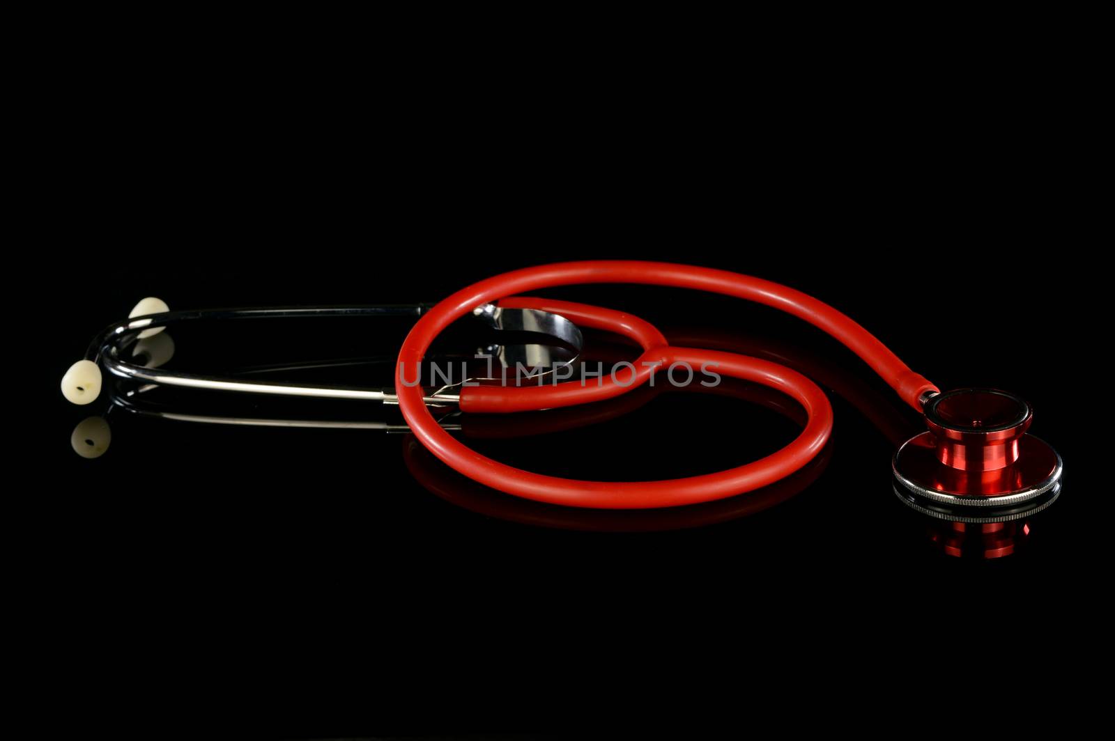 An isolated over black reflective surface medical stethoscope for clinical use.