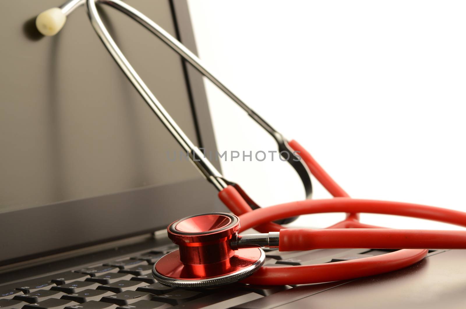 A stethoscope on a laptop for online healthcare services.
