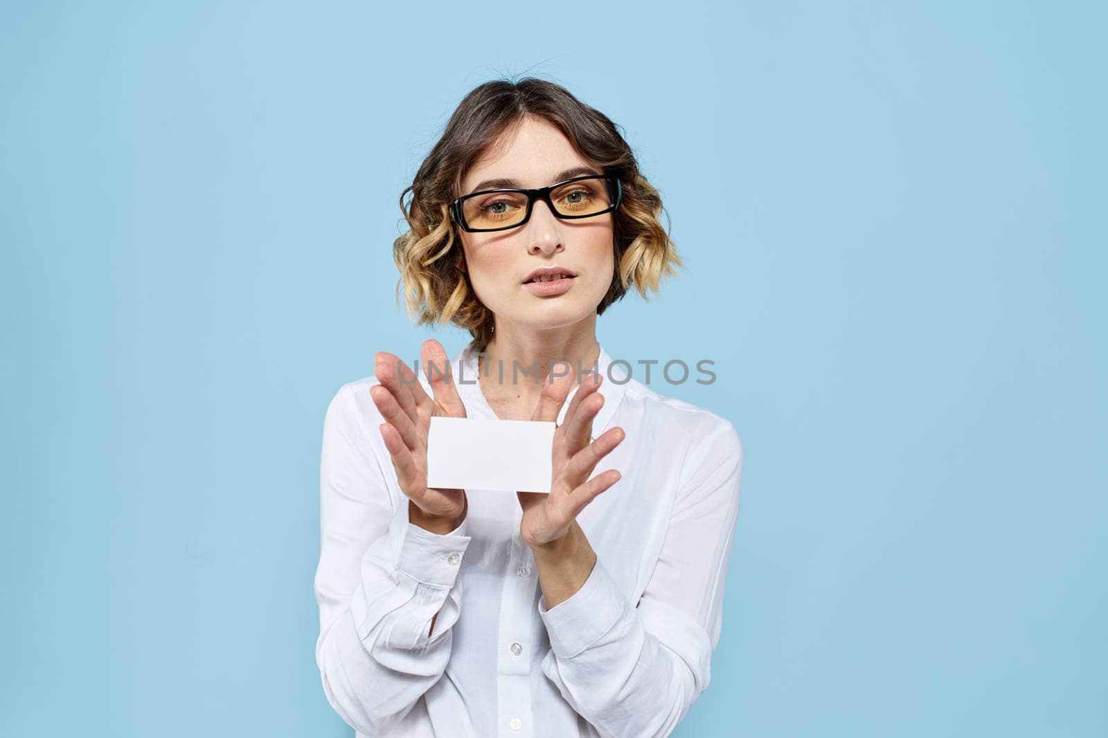 Woman wearing business card glasses in hands on blue background Copy Space cropped view. High quality photo