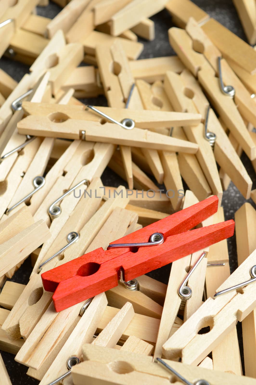 A unique red clothespin stands out from the rest.