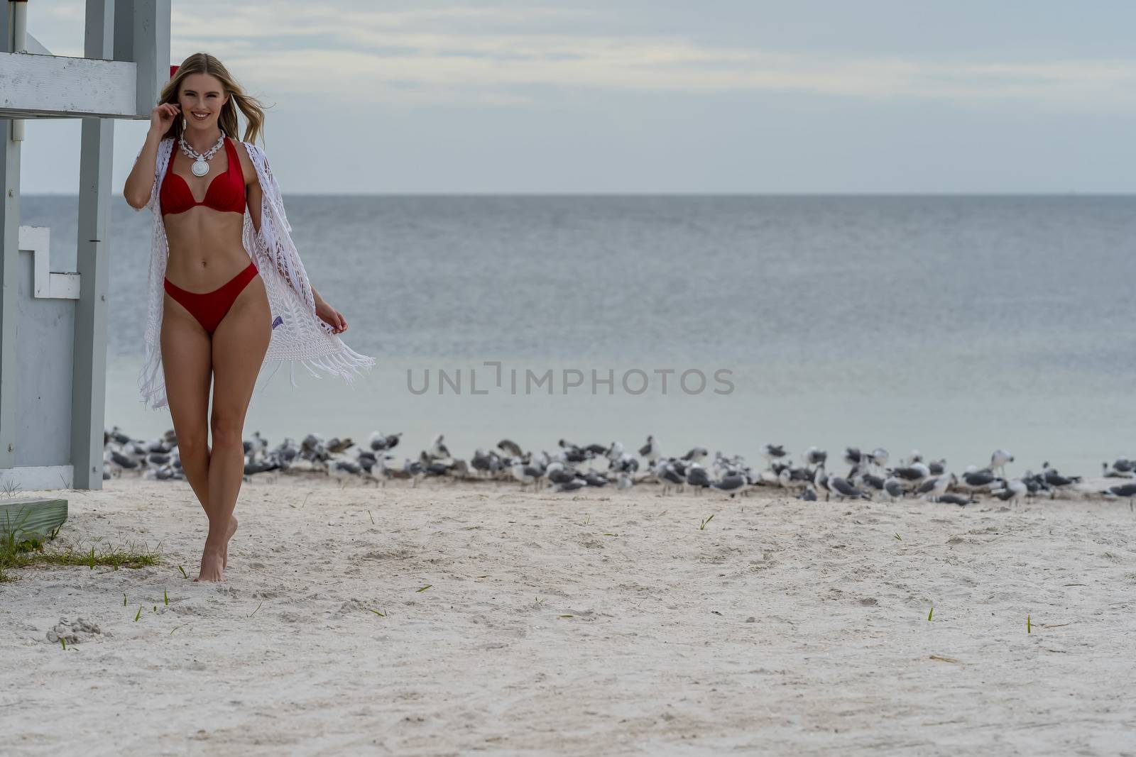 Lovely Blonde Bikini Model Posing Outdoors On A Caribbean Beach Near A Lifeguard Station by actionsports