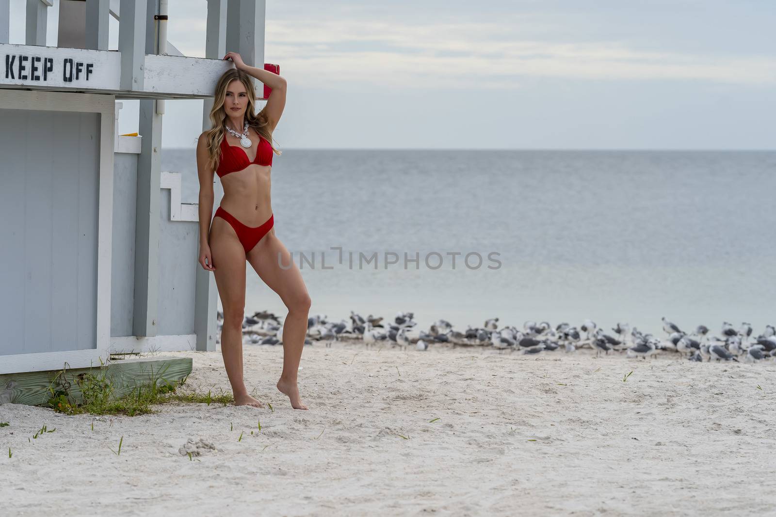 Lovely Blonde Bikini Model Posing Outdoors On A Caribbean Beach Near A Lifeguard Station by actionsports