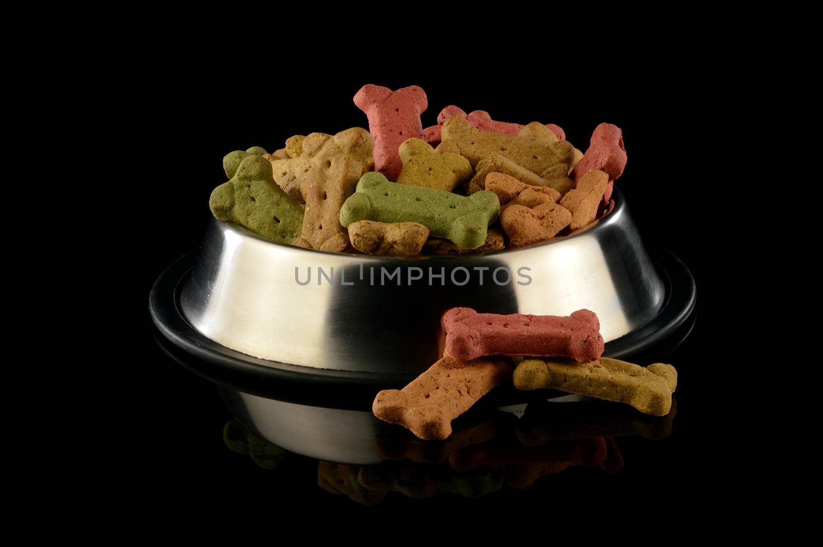 An overwhelming amount of dog treats inside a feeding dish over a black background.