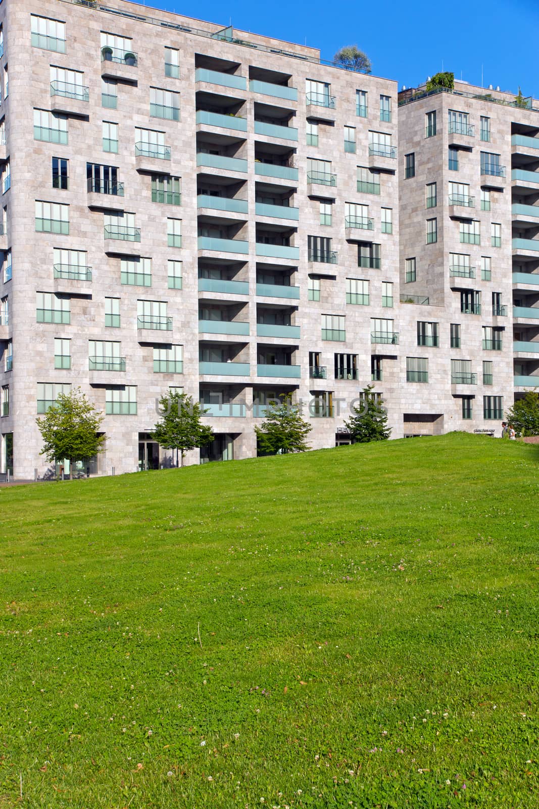 Beautiful grey apartment house with green grass in front of it