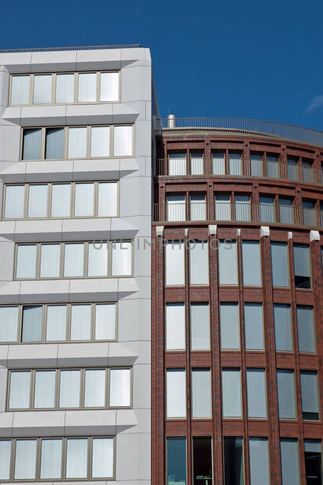 Two modern office buildings in Berlin with silver shutters