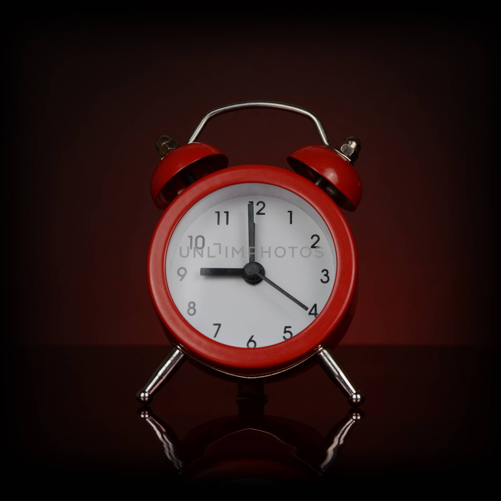 A closeup view of a vibrant red desk alarm clock.