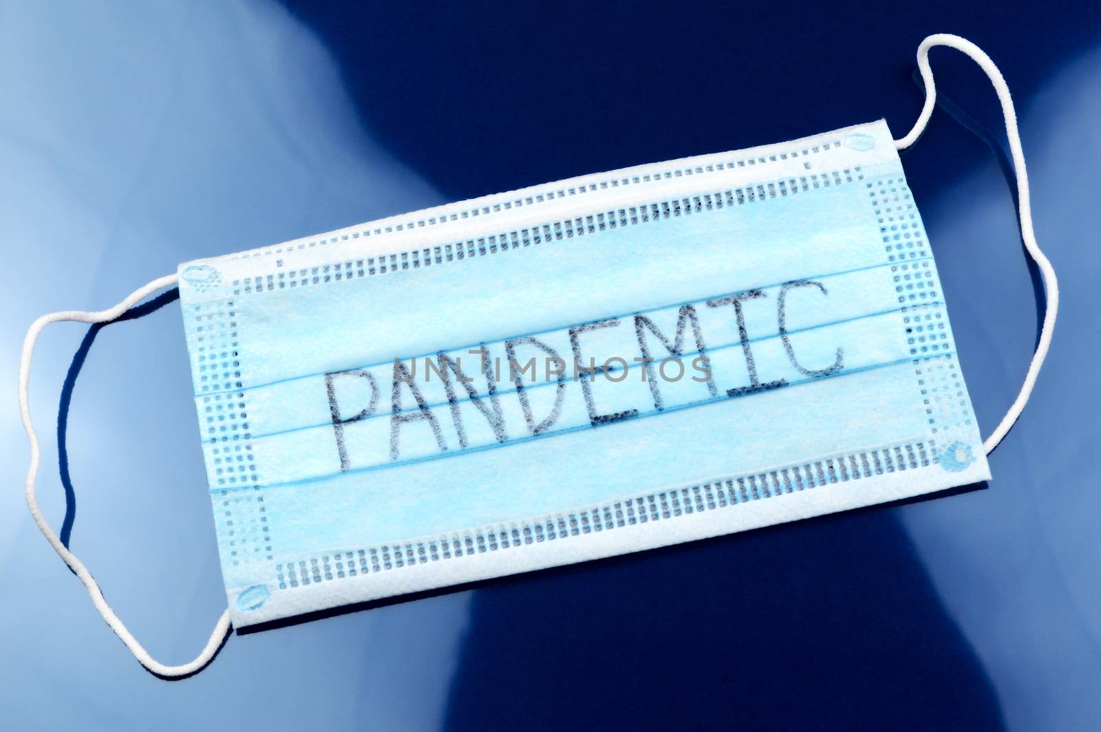 A face mask with the handwritten word Pandemic for the global Coronavirus outbreak starting in 2019.