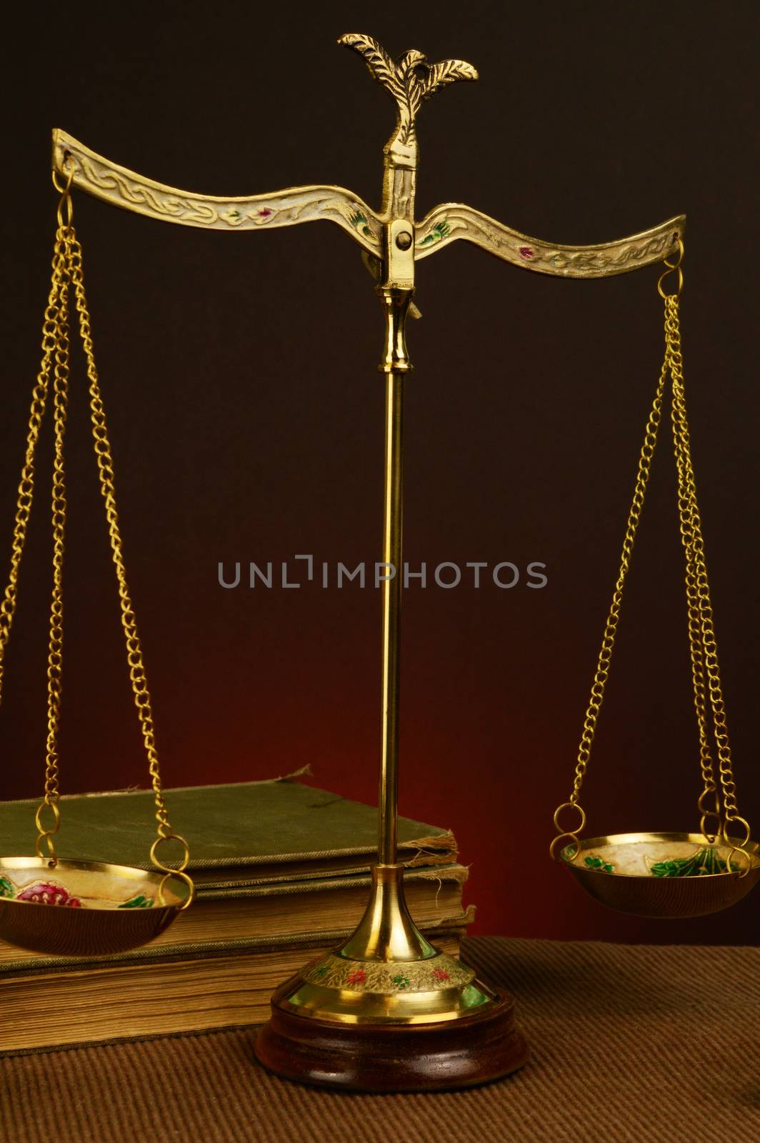 A vintage style image of an antique brass scale and books.