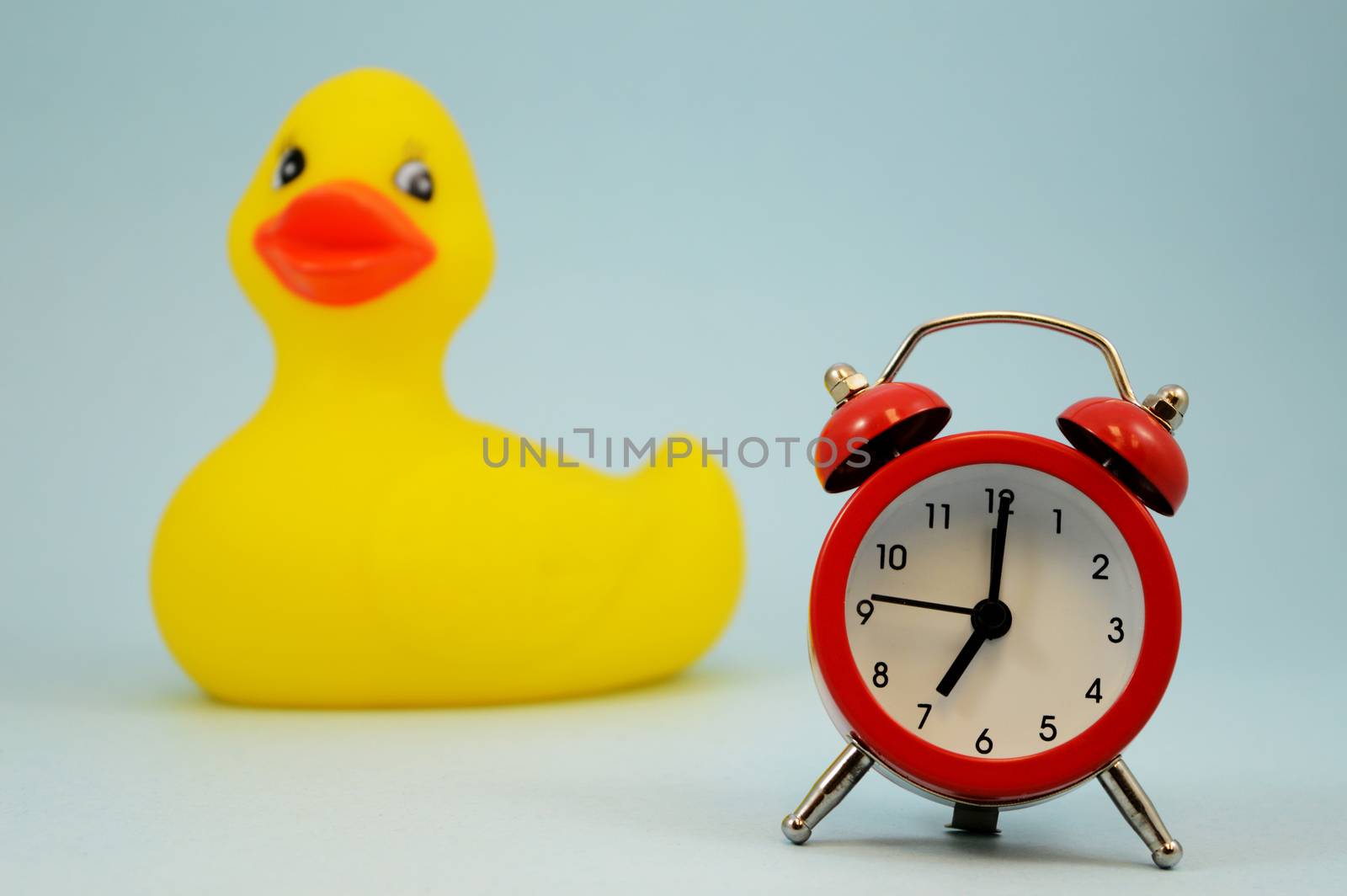 A red alarm clock and rubber ducky come together for scheduling bath time again.