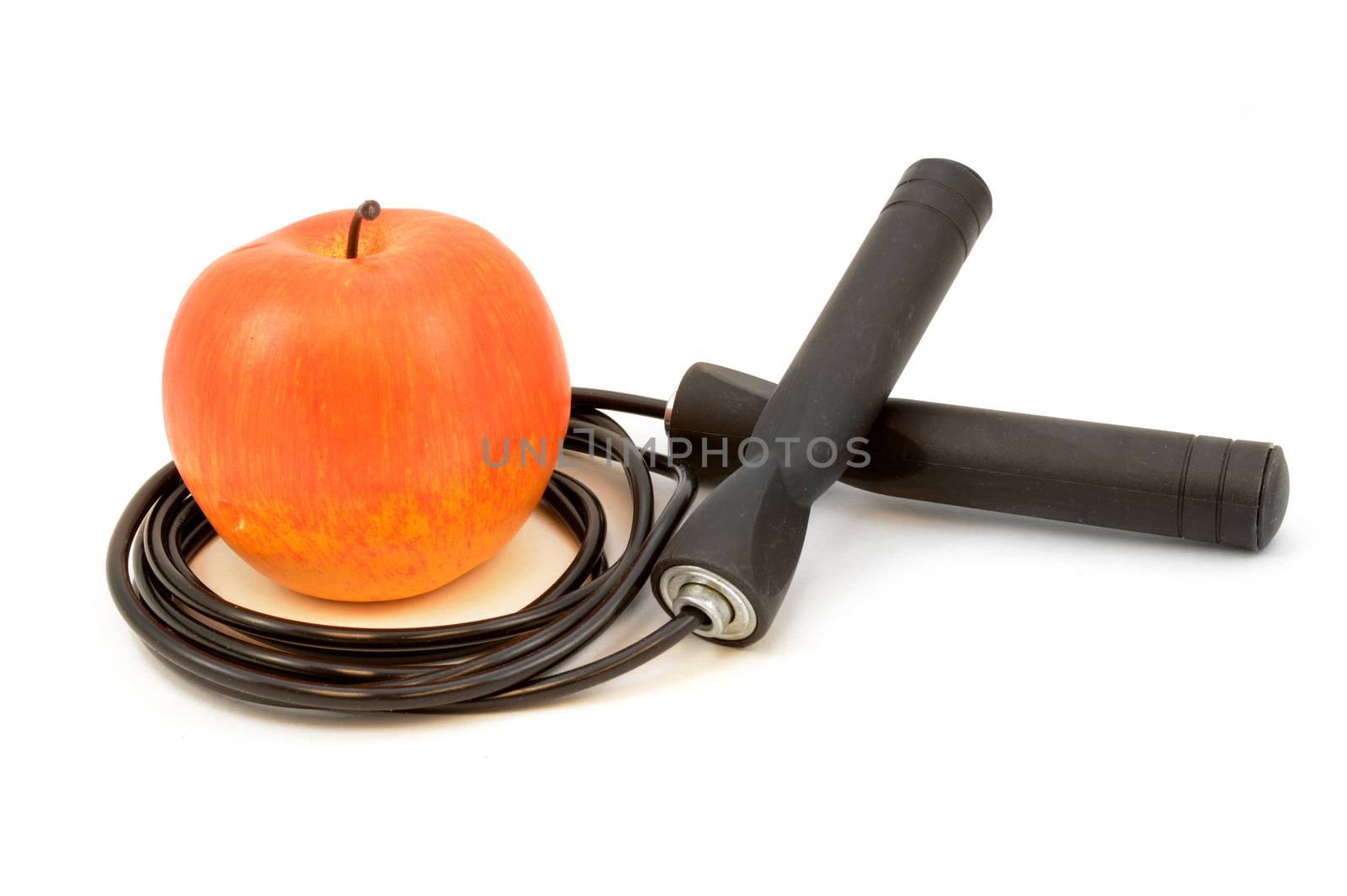 A red apple and black skipping rope isolated on white for health and fitness concepts.