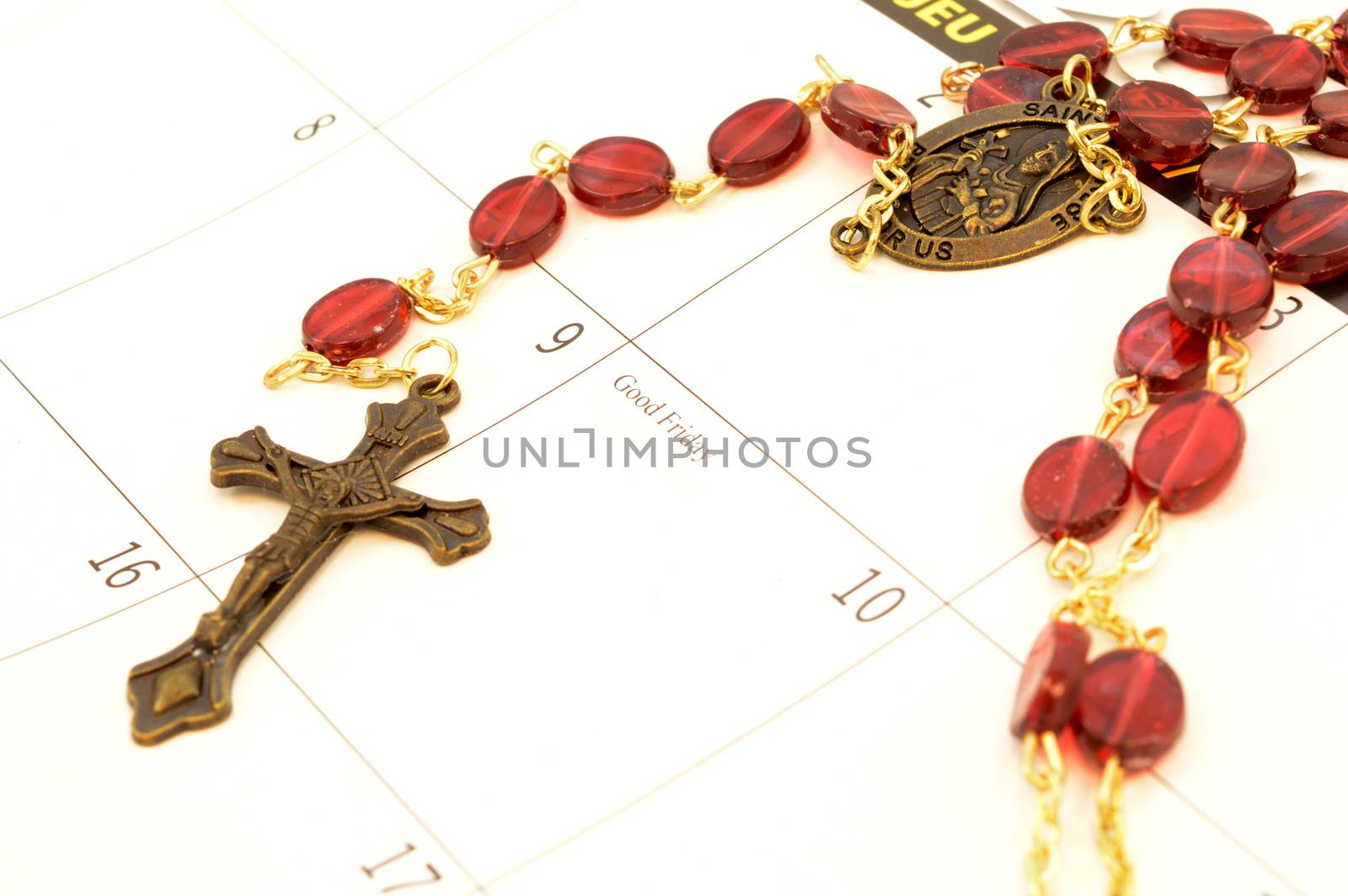 Good Friday is marked on the calendar for Easter with a closeup focus on a rosary cross and beads.