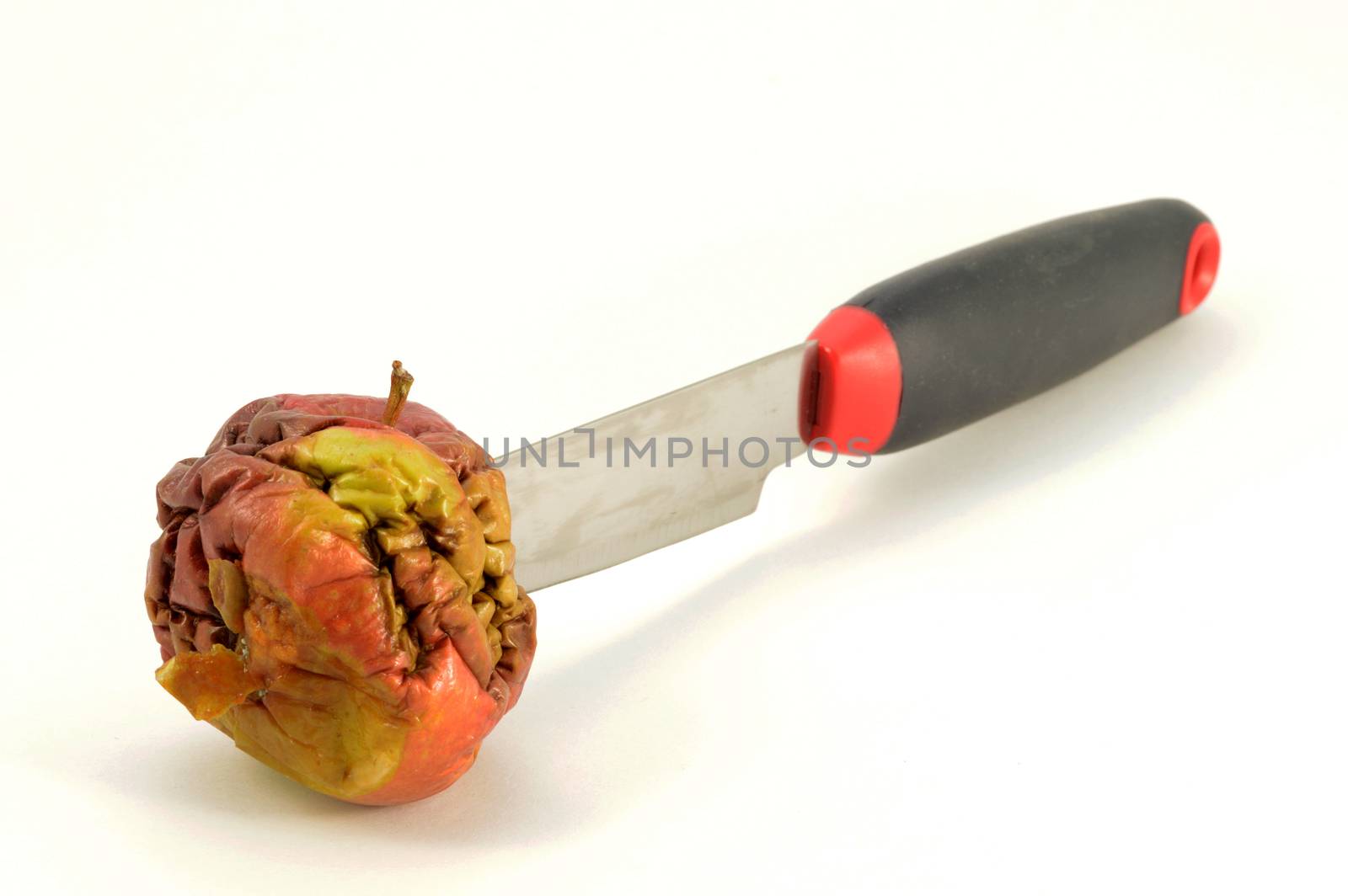 An isolated shot of one bad apple being cut with a knife.