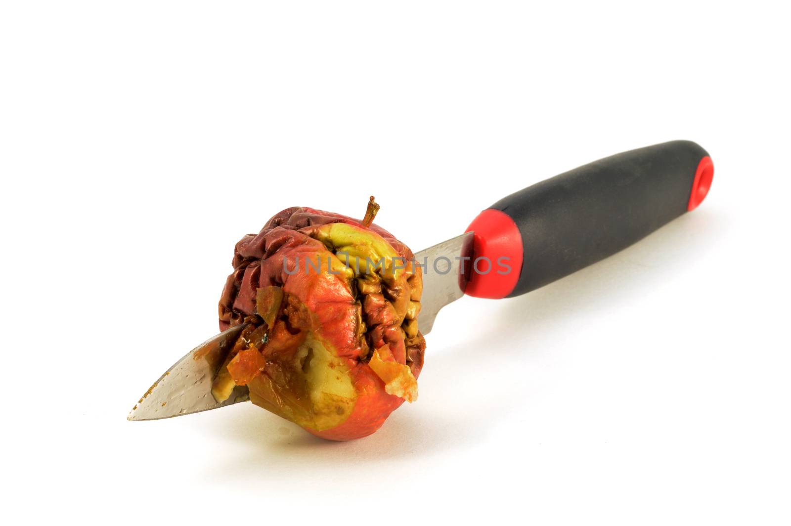 An isolated shot of one bad apple being cut by a knife.