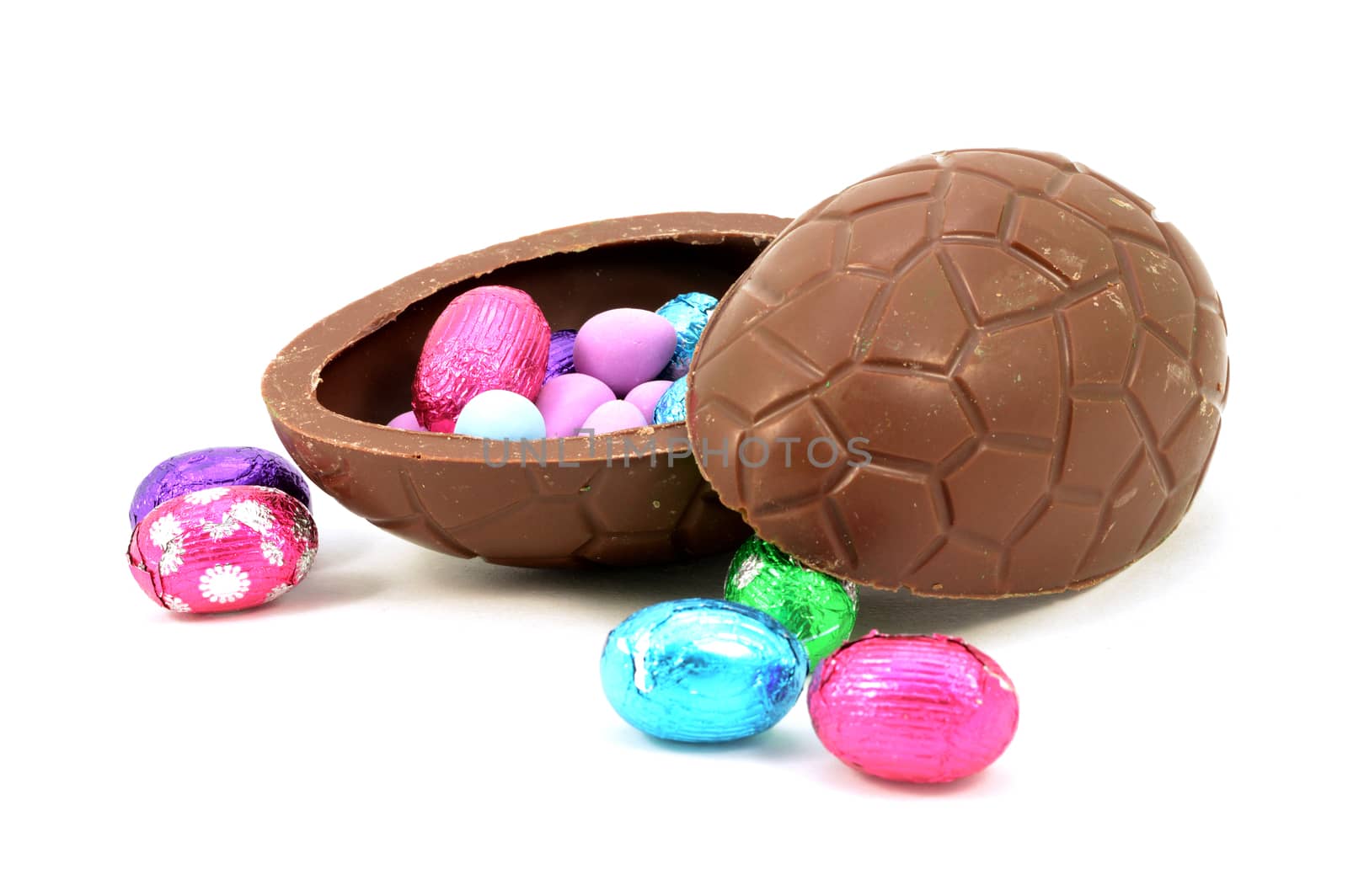 An isolated over white hollow chocolate Easter egg filled with candy.