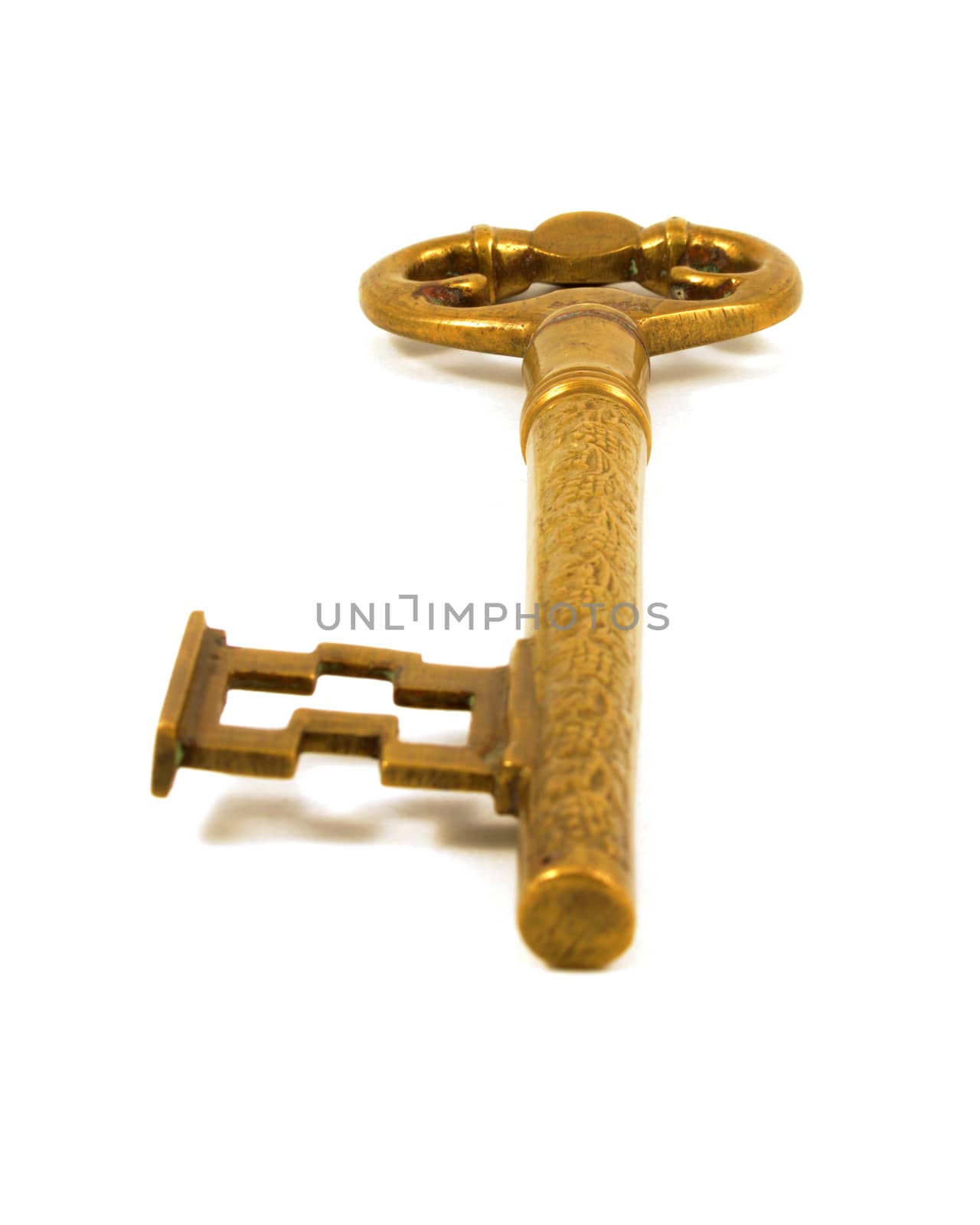 An isolated over white image of a large brass key.
