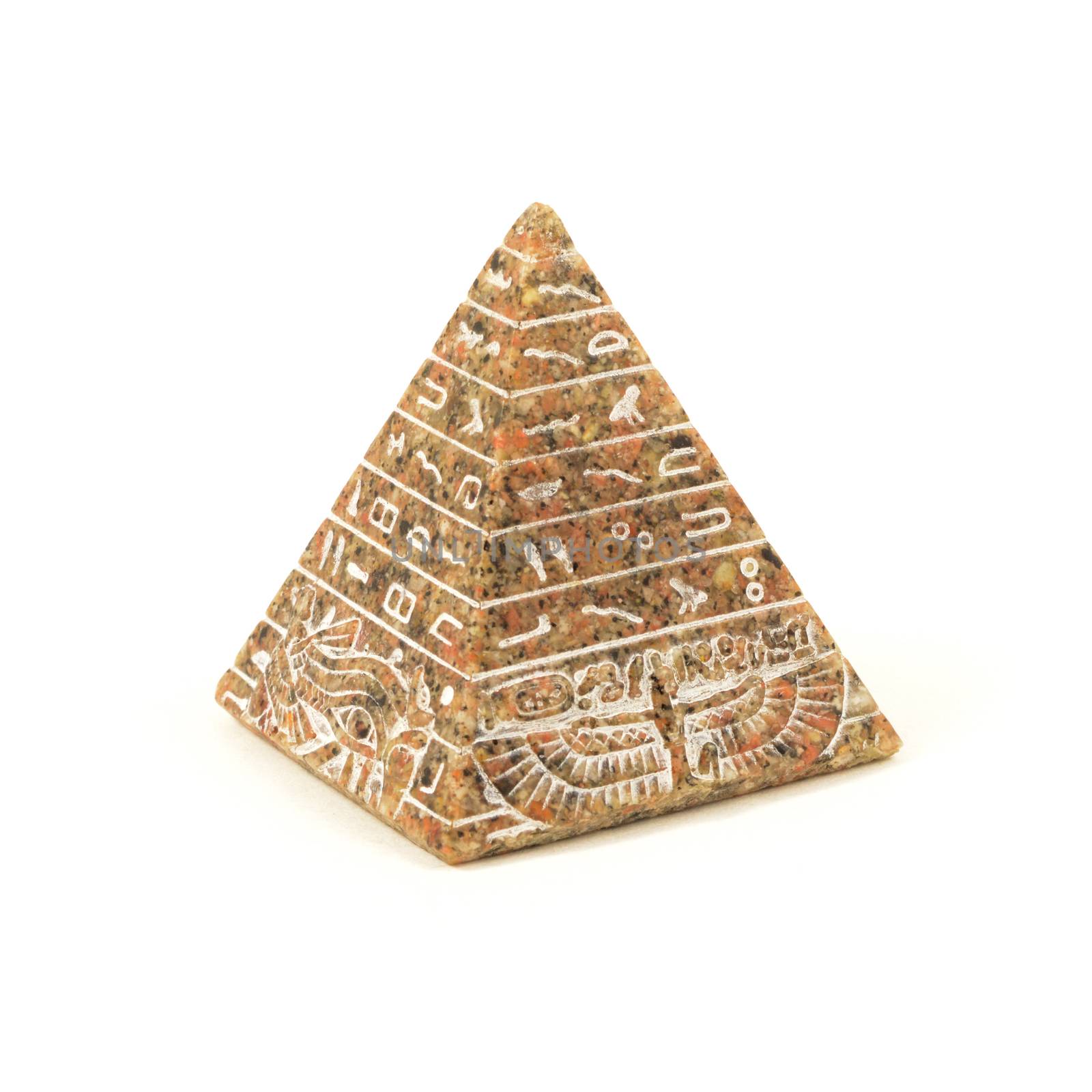 An isolated over white image of an Egyptian souviner of a handcrafted pyramid carved of stone.