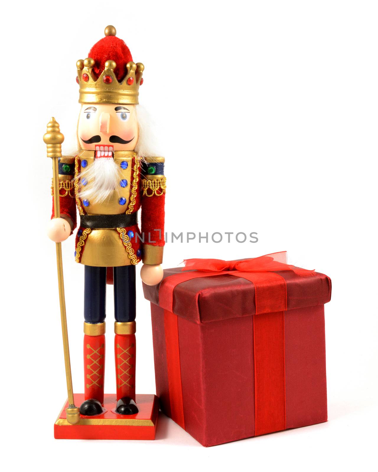 An isolated over white image of a king nutcracker with a red Christmas gift.