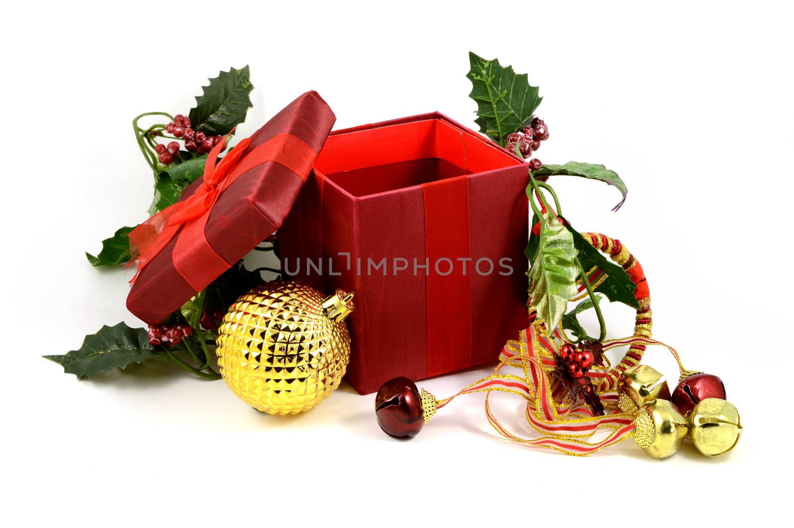 An isolated over white background image of an open red Christmas gift box with some compliamenting decorations added.