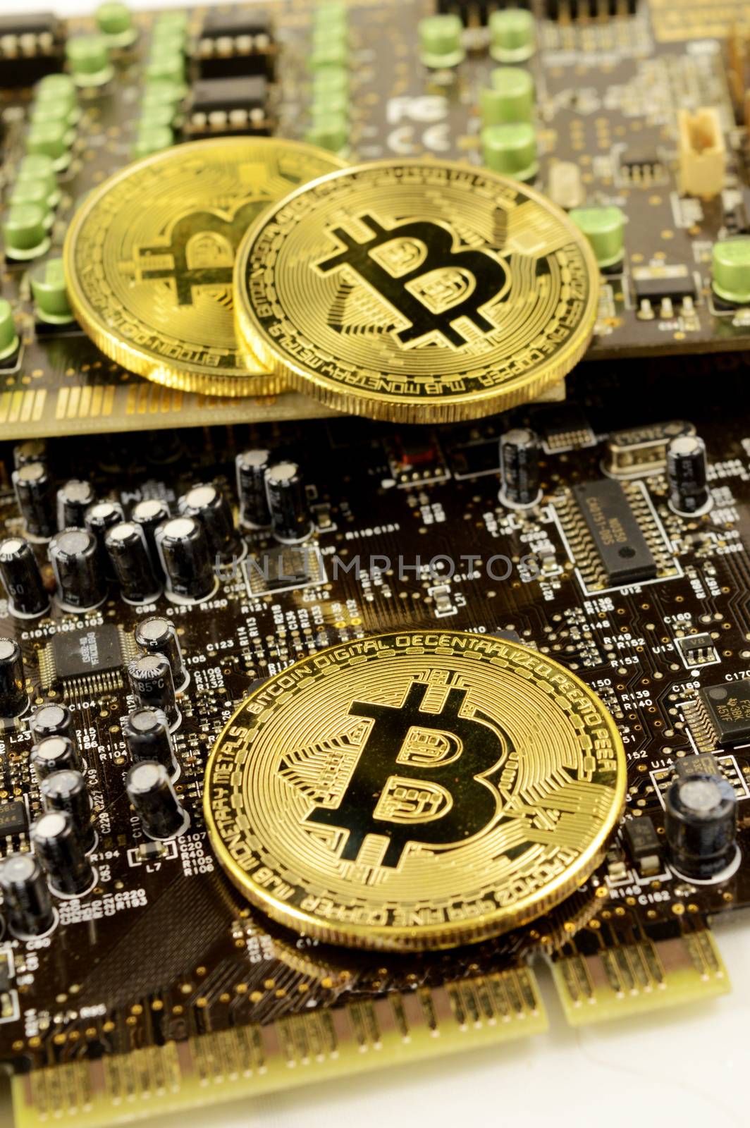 Closeup view of Bitcoins resting on top of a circuit board for showing the digital cryptocurrency details.