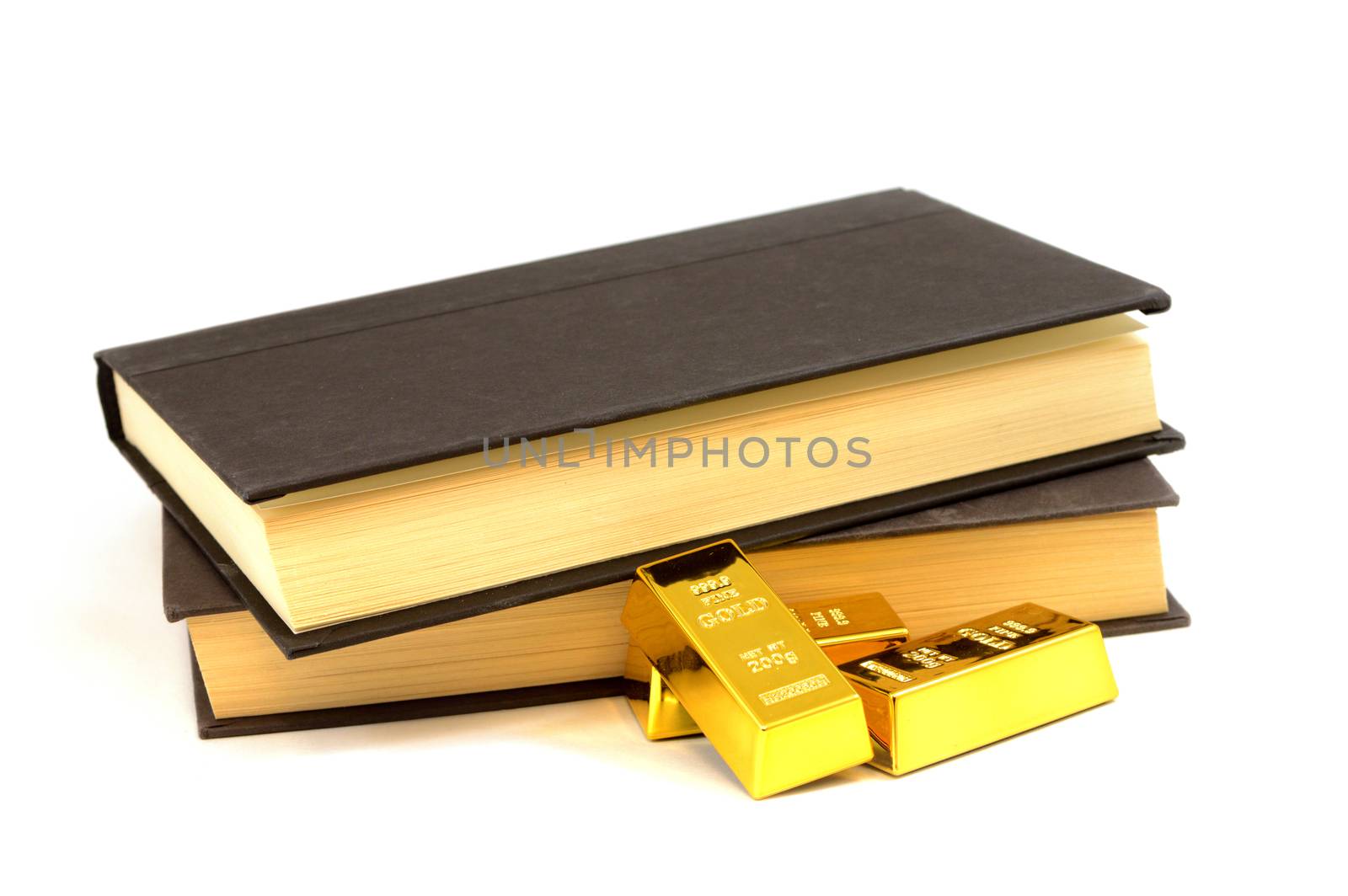 An isolated set of books and some gold bullion bars for the study on ways to make proper investments.