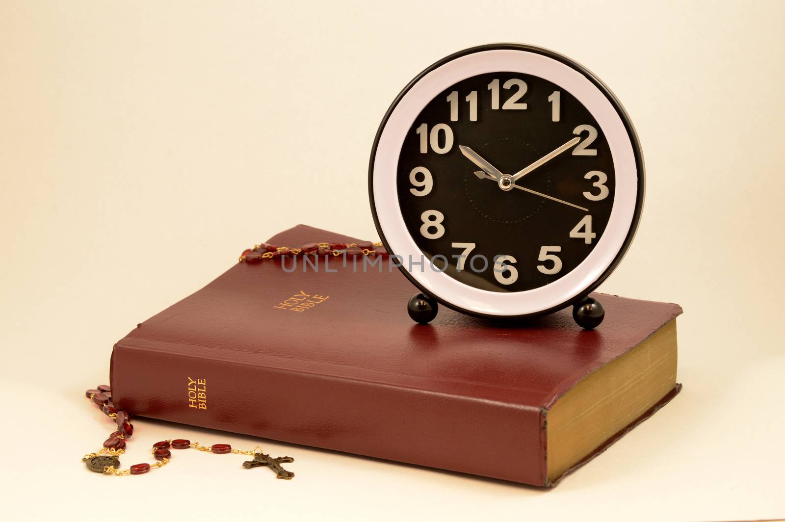 A clock and holy bible come together over a warm pink background to give meaning to various times and dates used to reference the good book.