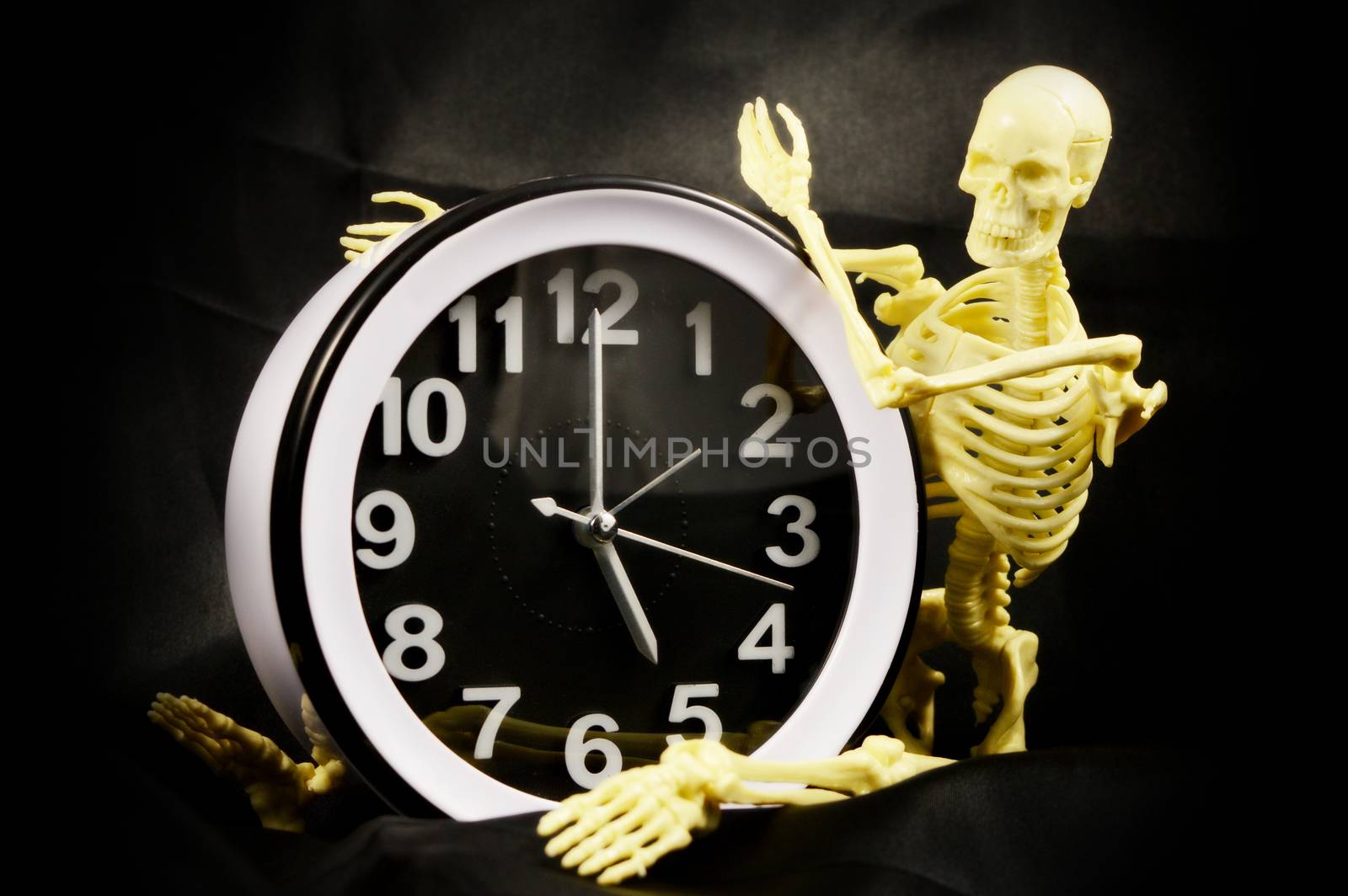 A conceptual image of being worked to the bone using a five pm time clock and a human skeleton.